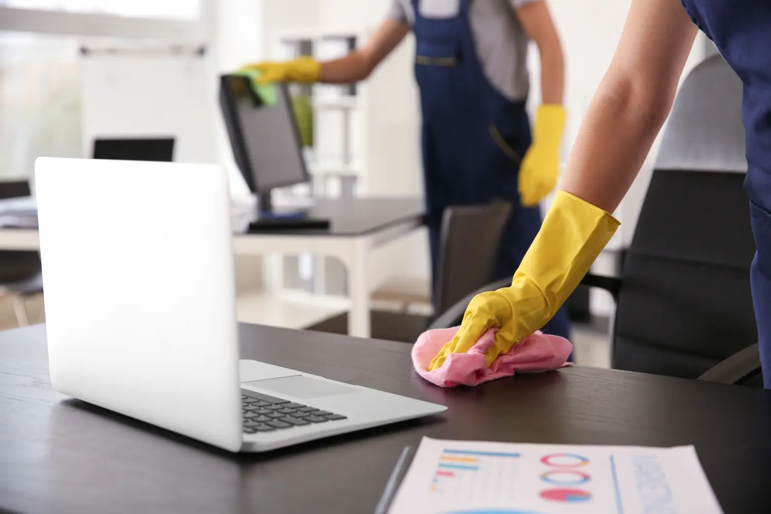 Hausmeister wischt Tisch im Büro
