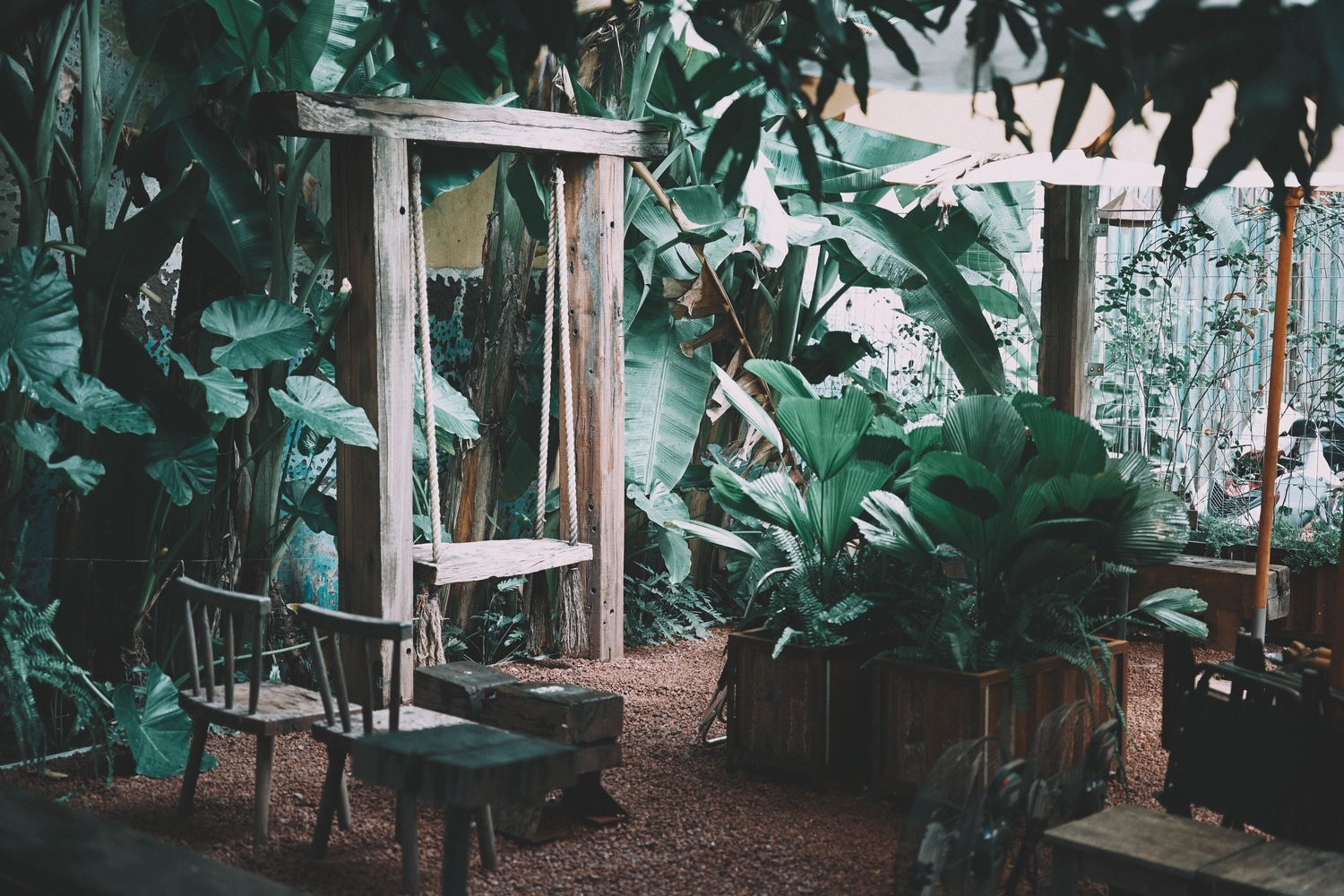 Splinta Clean GmbH – Gebäudereinigung – Diese rustikale Holzschaukel steht in einem üppigen Gartencafé in Da Nang, Vietnam.